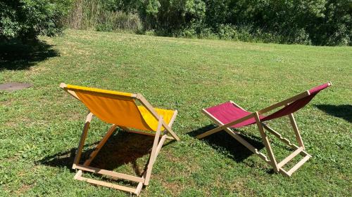 twee stoelen op het gras in een tuin bij Joli Appartement 27m2 Terre d'Ocre en village vacances en Camargue in Arles