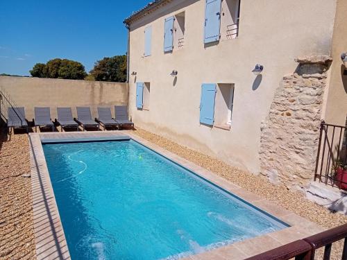 une piscine devant un immeuble dans l'établissement Ferme de l'Arnesque, à Châteauneuf-du-Pape