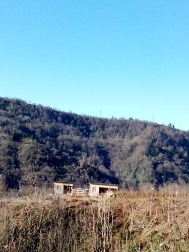 two houses on a hill in front of a mountain at Breathe Inn in Batumi