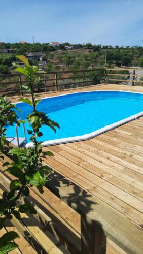 a blue swimming pool on a wooden deck at Casa do Olival - Apartamento T4 in São João da Pesqueira