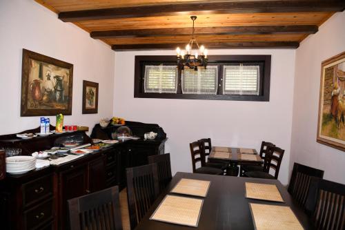 a dining room with a table and a kitchen at Hotel Restaurant Dreri in Tirana