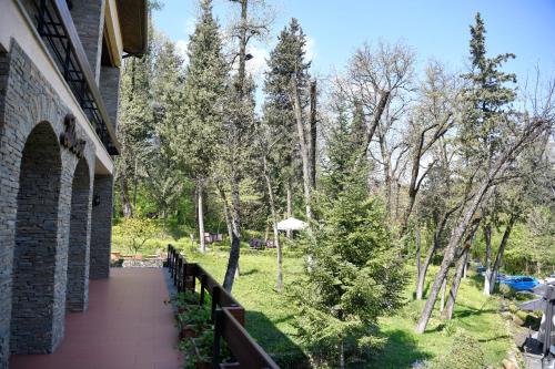 a balcony of a building with trees and a walkway at Hotel Restaurant Dreri in Tirana