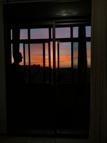 een persoon die uit een raam kijkt bij zonsondergang bij King castle in Ramallah