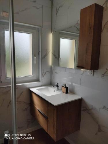 une salle de bain avec un lavabo et un miroir dans l'établissement Le Nid de la Baie, à Crollon