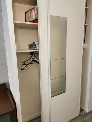 a closet with a mirror next to a door at Appart Hotel La Defense in Courbevoie