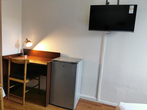 a room with a desk with a small refrigerator and a lamp at Appart Hotel La Defense in Courbevoie