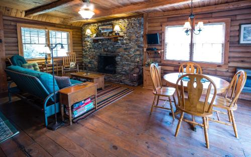 a living room with a table and a fireplace at Creekside Hideaway Rustic Cabin - Secluded, Creekside Family Cabin in Topton