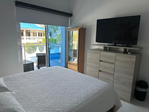 a bedroom with a bed and a flat screen tv at ATLANTIS CASA BOUTIQUE , con jacuzzi cerca de la playa in San Andrés