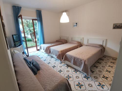 a hotel room with three beds and a tv at Sun Terrace Sorrento in Sorrento