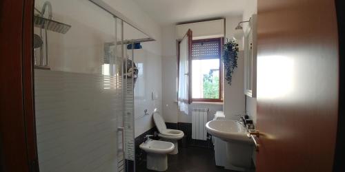 łazienka z 2 toaletami, umywalką i prysznicem w obiekcie La Fenice w mieście Arcore