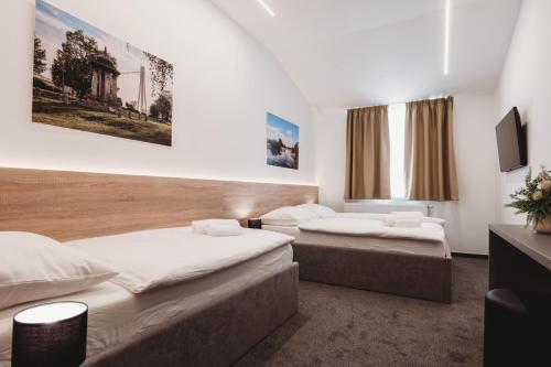 a bedroom with two beds and a tv at Bells Osijek in Osijek