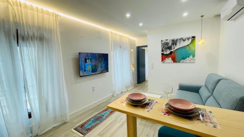 een woonkamer met een blauwe bank en een tafel bij Apartamentos BRAVO MURILLO con garaje en centro histórico in Badajoz