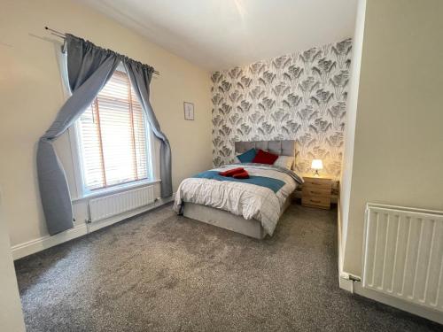 a bedroom with a bed and a large window at The First Rho in Bishop Auckland