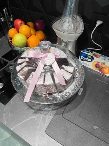 a cake on a counter with a pink ribbon on it at Gioia Home in Pompei