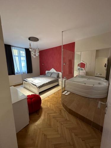 Lux apartments Top center في صوفيا: غرفة نوم مع حوض استحمام وسرير وحوض استحمام