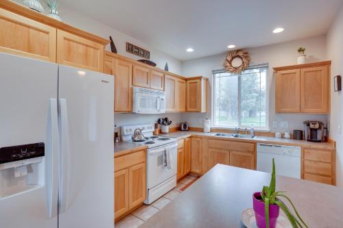 a kitchen with wooden cabinets and a white refrigerator at Charming Redmond Townhome with Resort Amenities in Redmond