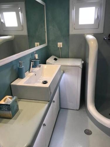 a bathroom with a sink and a mirror at Costa Ilios 2 bedroom flat in Ornos