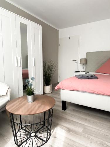 Exclusives Apartment in Toplage في فيلهلمسهافن: غرفة نوم بسرير وطاولة مستديرة
