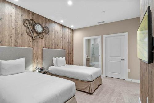 a bedroom with two beds and a clock on the wall at Beautiful 4 suites - Close to Disney 7505 in Orlando