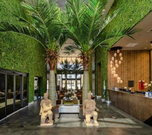 a lobby with palm trees and statues in a building at Beautiful 4 suites - Close to Disney 7505 in Orlando