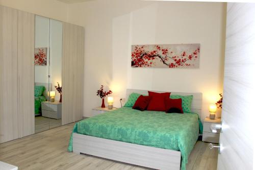 a bedroom with a bed with red pillows at LA CASA DI FRANCESCO in Putifigari