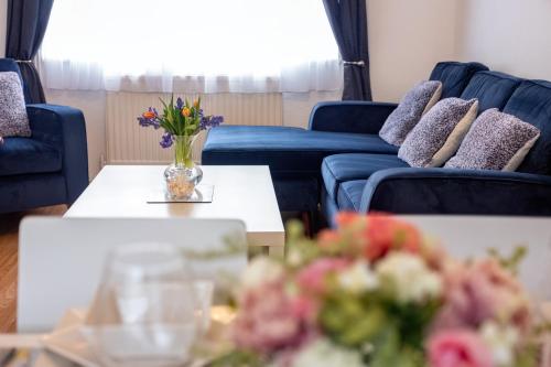 a living room with couches and a vase of flowers on a table at 6bed Perfect stay! Contractors welcome! in Peterborough