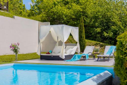 a tent and chairs next to a swimming pool at Villa Plešivica view in Plešivica