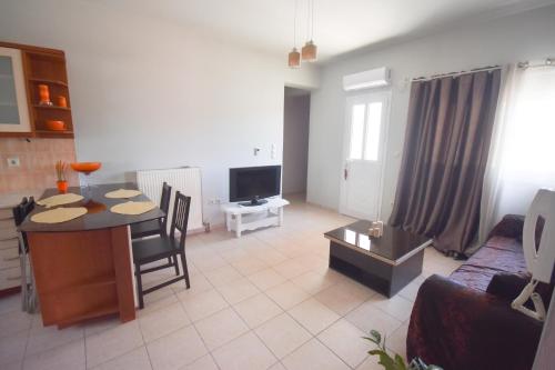 a living room with a couch and a table and a tv at K&C Rooms- Apartments in Markopoulo