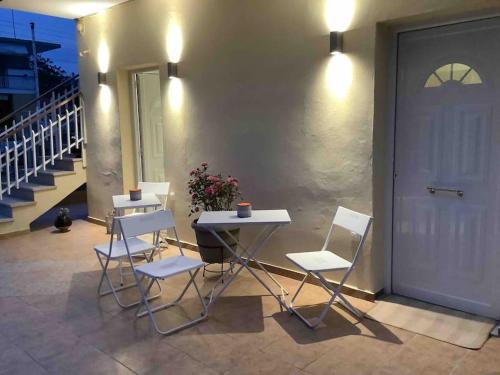 a table and chairs on a patio with a door at NG Luxury Apartments at Nea Kallikrateia No 1 in Nea Kalikratia