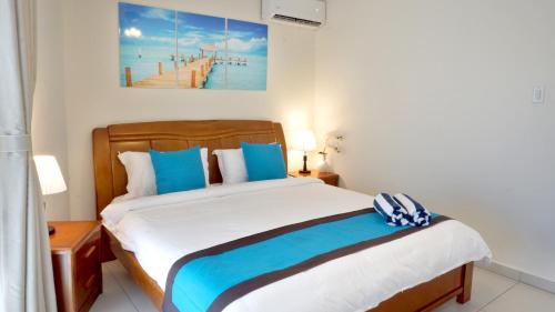 a bedroom with a large bed with blue pillows at Arena Condominium Aruba in Palm-Eagle Beach