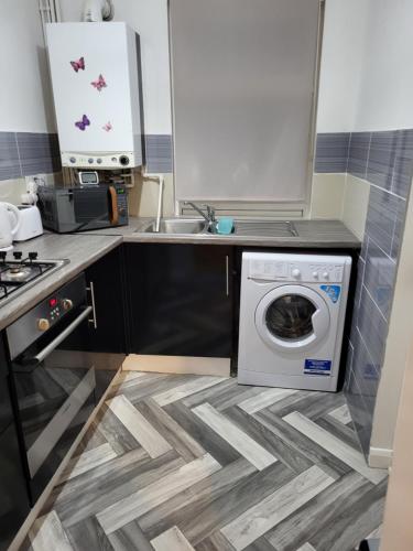 a kitchen with a washing machine and a sink at House 36 in Liverpool