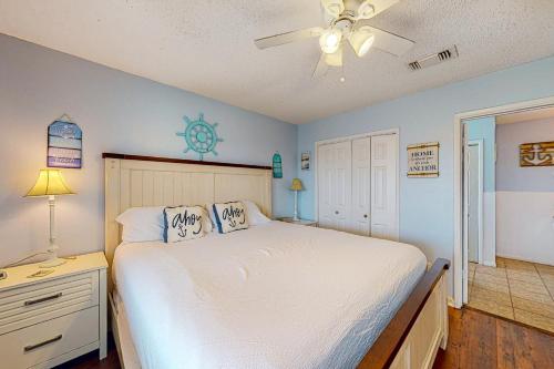 Schlafzimmer mit einem Bett und einem Deckenventilator in der Unterkunft Captain's Quarters in Galveston