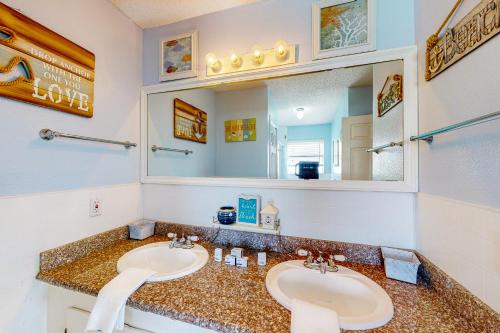 ein Badezimmer mit zwei Waschbecken und einem großen Spiegel in der Unterkunft Captain's Quarters in Galveston