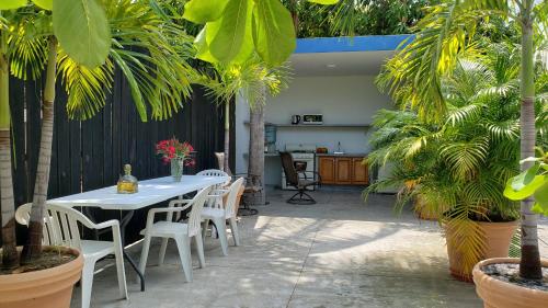 a patio with a table and chairs and palm trees at VIP Trailer Park and Bungalows. in Barra de Navidad