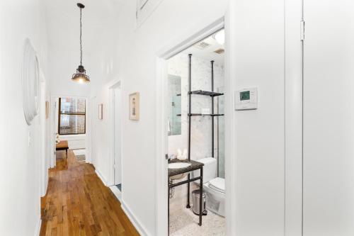 a white bathroom with a toilet and a sink at Luxurious 3 BR SOHO in New York