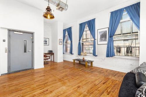 a living room with blue curtains and wooden floors at Luxurious 3 BR SOHO in New York