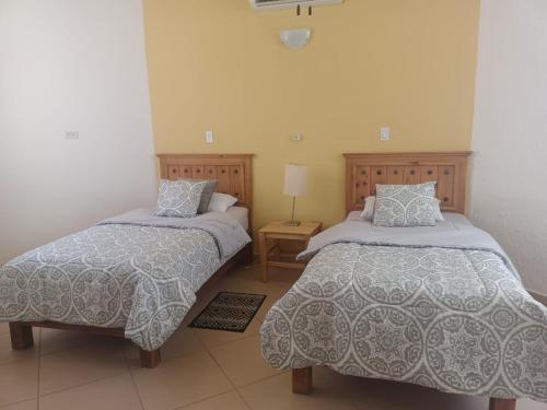 1 dormitorio con 2 camas y mesa con lámpara en GoBaja Villas 3 bedroom en La Paz