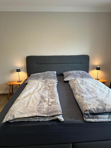 a bed with two pillows on it with two tables at Steinweg 7 Ferienwohnung in Kassel