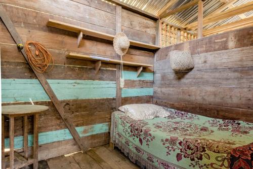 een slaapkamer met een houten muur met een bed en een tafel bij Bribri ù sule in Suretka