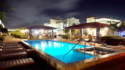 a swimming pool at a resort at night at Arena Condominium Aruba in Palm-Eagle Beach