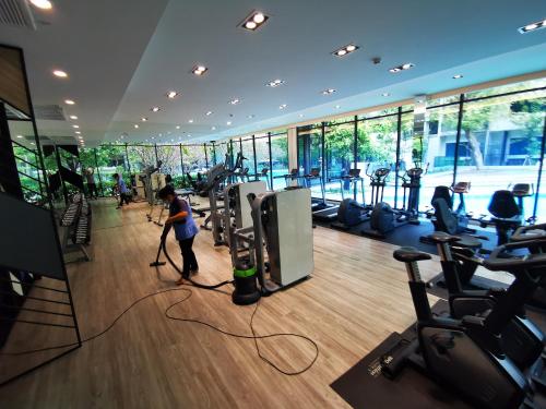 a man is cleaning a gym with a vacuum at Blossom condo in Yan Nawa