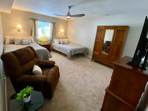 Croatan Beach House - Big Kitchen, Hot Tub, 2 Masters في فرجينيا بيتش: غرفة معيشة مع سرير وأريكة