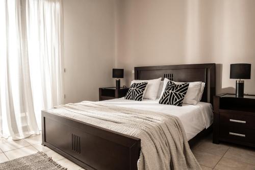 a bedroom with a large bed with black and white pillows at Amalthia Villa in Mouzákion