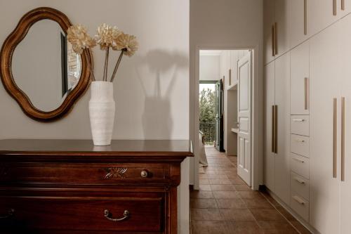 a vase of flowers on a dresser in a hallway at Amalthia Villa in Mouzákion