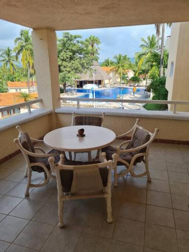 - Balcón con mesa y sillas y vistas a la piscina en 2 Bedroom 2 bathroom condo pool, tennis beach club, en Manzanillo