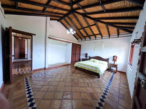 1 dormitorio con cama y techo de madera en casa campestre el KFIR, en Villa de Leyva