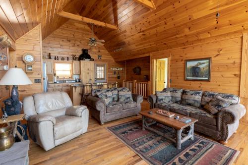 a living room with couches and a table in a cabin at Quiet Haven Mountain Top Cabin - 3 Bedroom Cabin with Breathtaking Views in Topton
