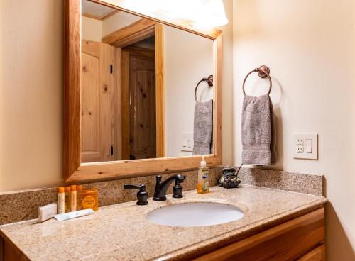 a bathroom with a sink and a mirror at Quiet Haven Mountain Top Cabin - 3 Bedroom Cabin with Breathtaking Views in Topton