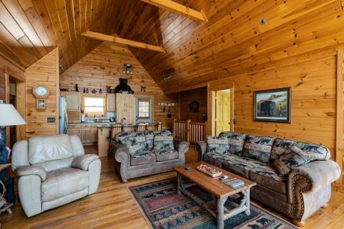 a living room with couches and a table in a cabin at Quiet Haven Mountain Top Cabin - 3 Bedroom Cabin with Breathtaking Views in Topton