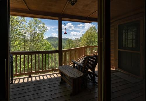 a porch with a bench and a view of the mountains at Quiet Haven Mountain Top Cabin - 3 Bedroom Cabin with Breathtaking Views in Topton